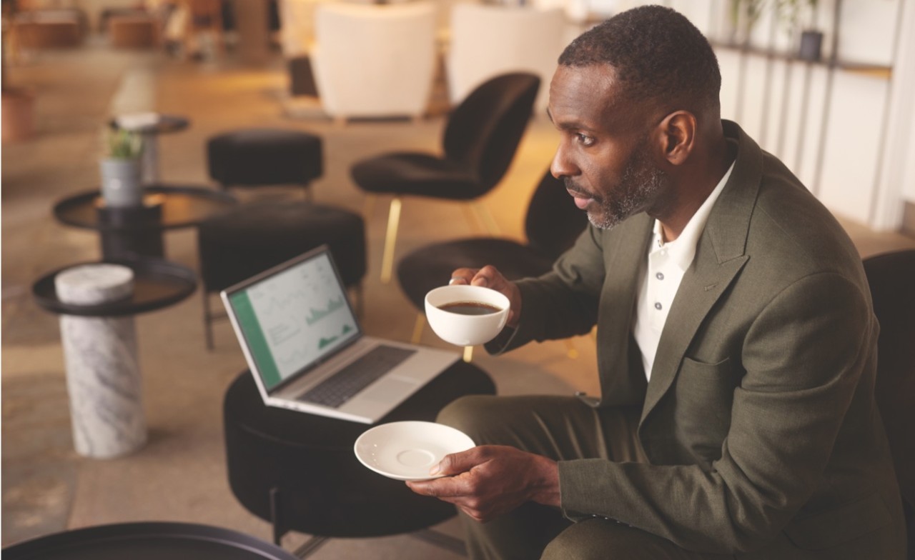 Image of a business man with a coffee and laptop