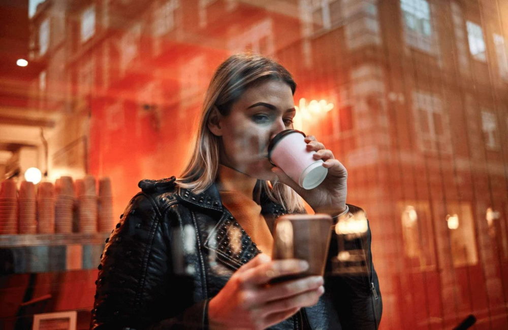 Girl drinking coffee using her phone