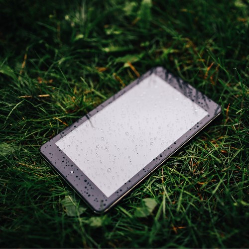 A tablet lying in grass in the rain