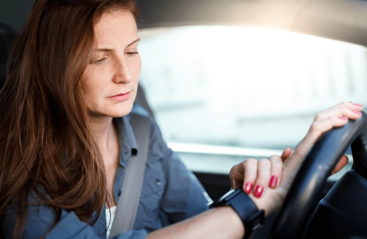Woman checking her smartwatch whilst stationary in a car