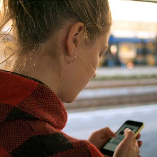Young woman using phone in a train station