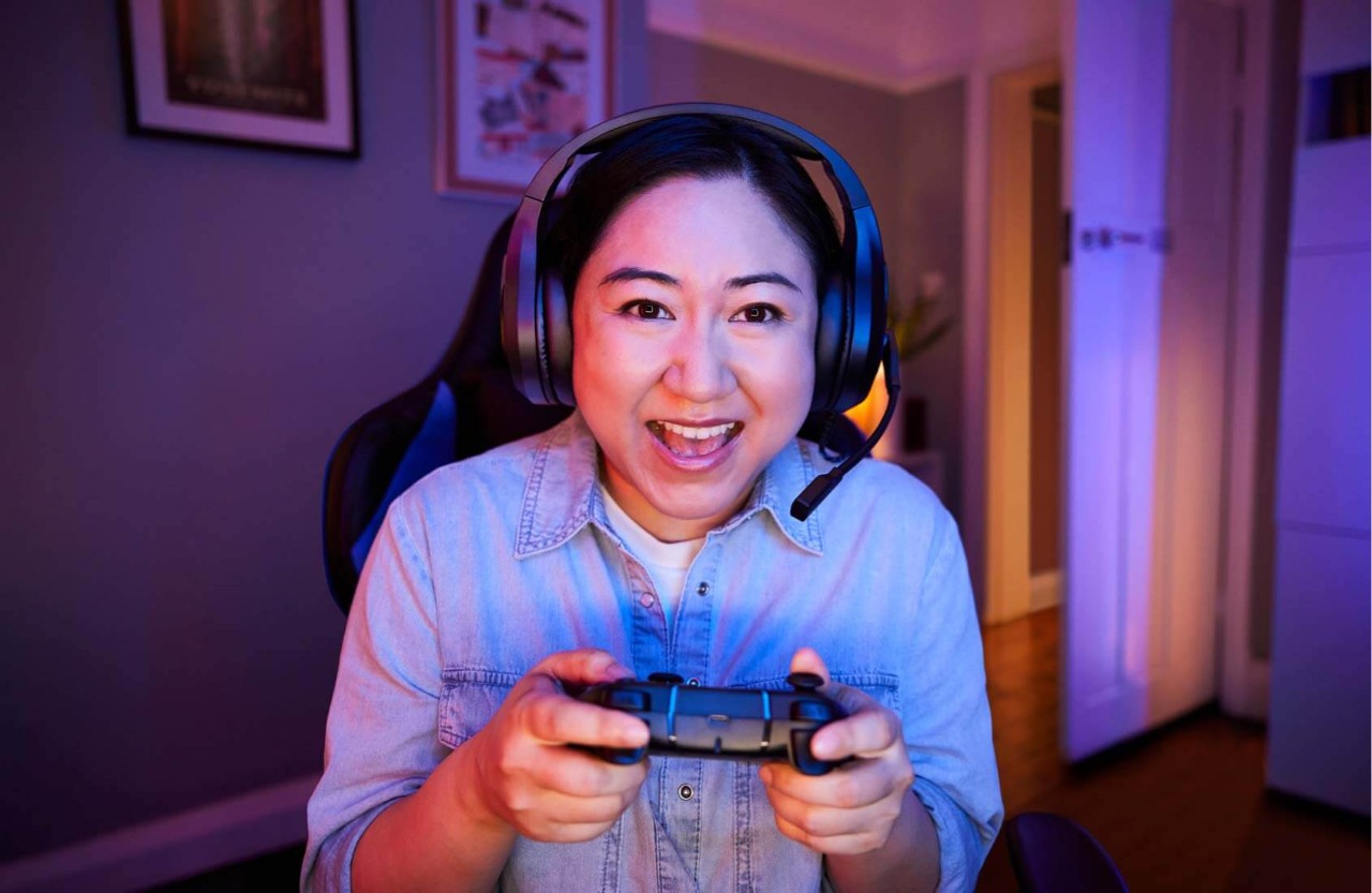 Person gaming wearing headset and holding a controller