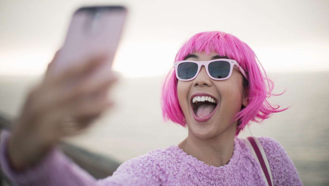 Woman with pink hair taking a selfie