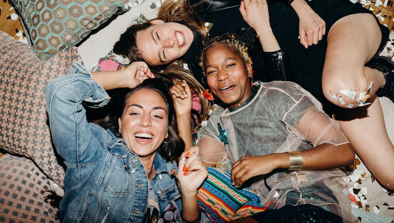 Group of women laughing at a party with confetti