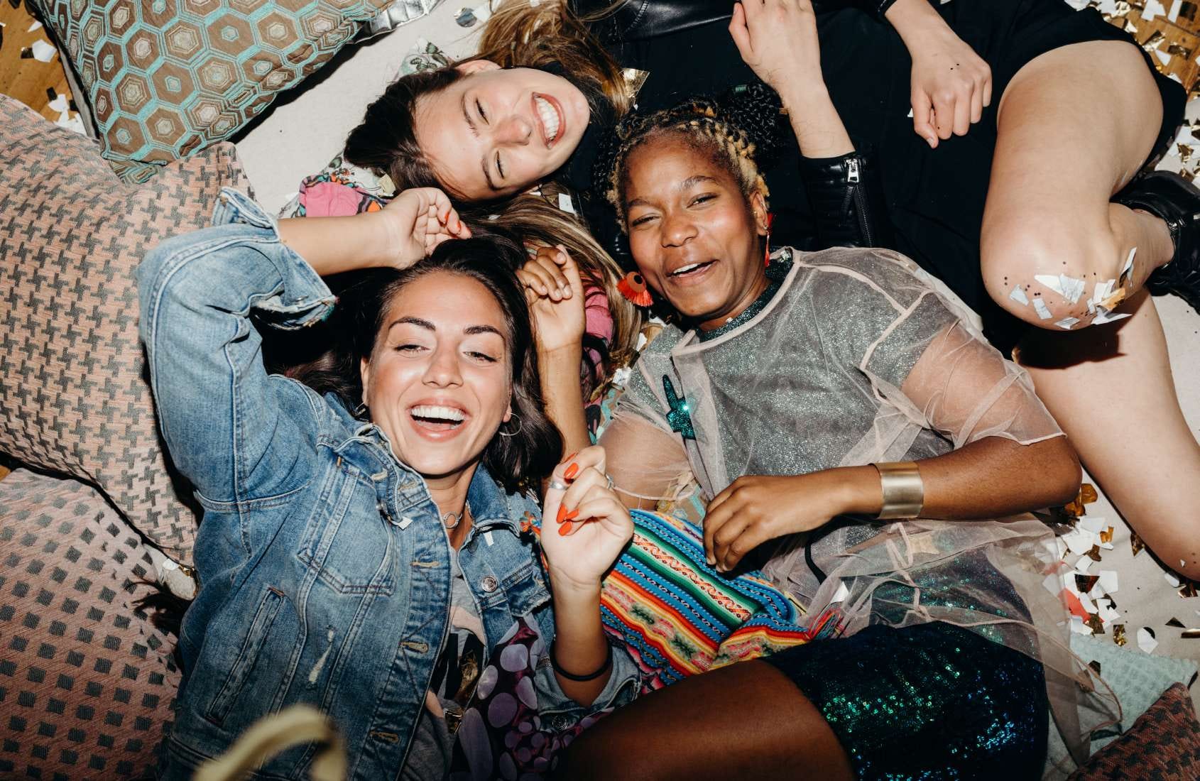 Group of women laughing at a party in confetti