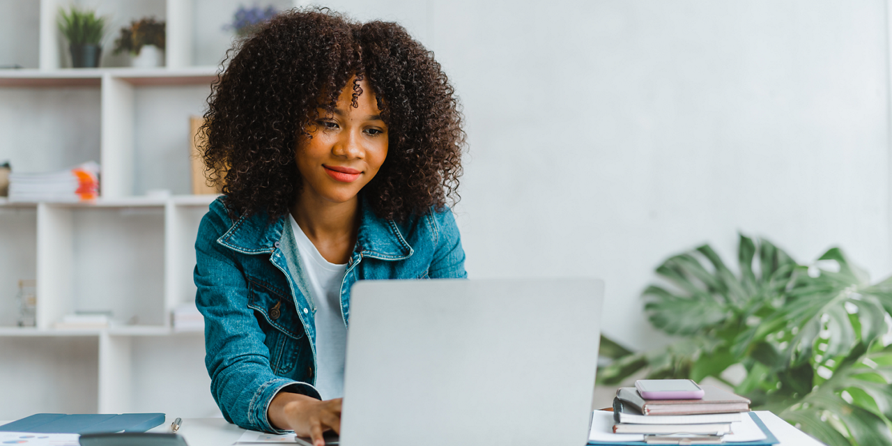 Lady in denim shirt working on laptop