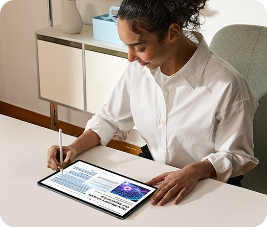 A woman sits at a desk working on Galaxy Tab S12 Ultra with an S Pen in hand. The tablet is in landscape mode. She uses the S Pen to highlight text in the article and use Note Assist to create a concise summary.