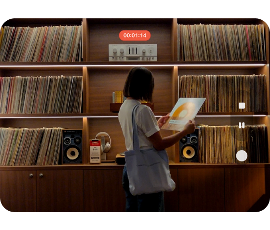 A woman standing in front of a shelving unit filled with vinyls and speakers, with a recording icons overlay. 