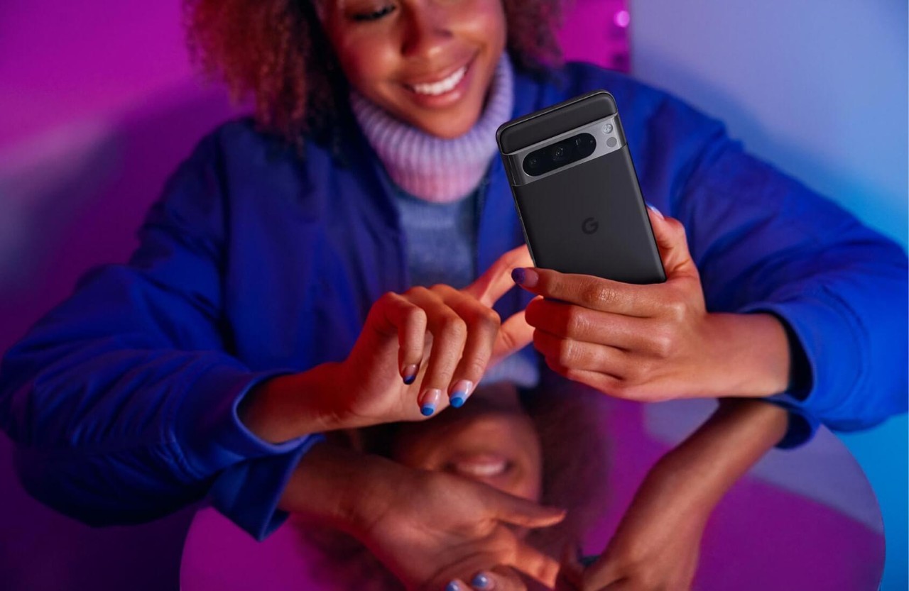 Image of a person smiling whilst using their phone