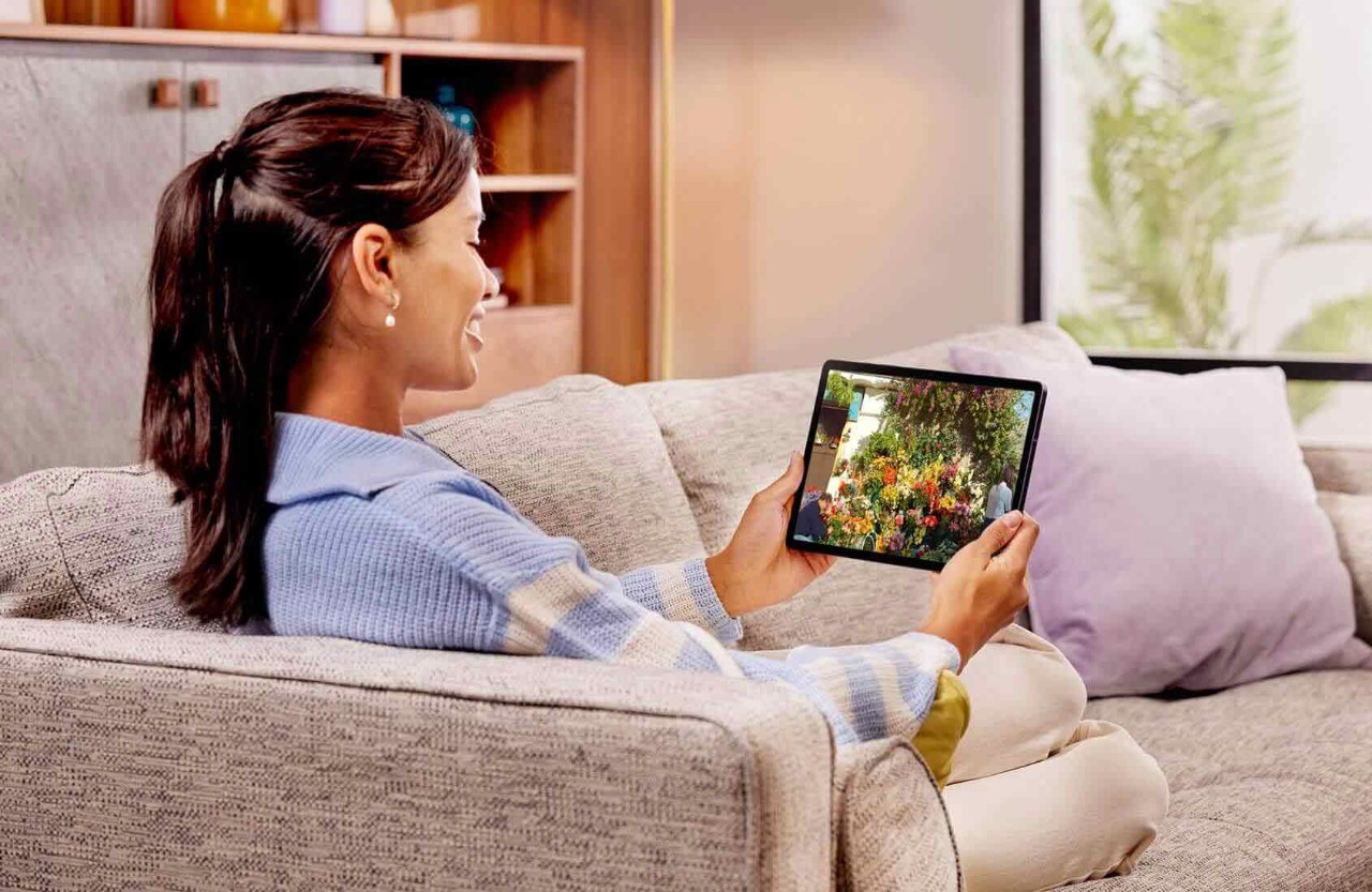 Person sitting on a sofa with a tablet in hand